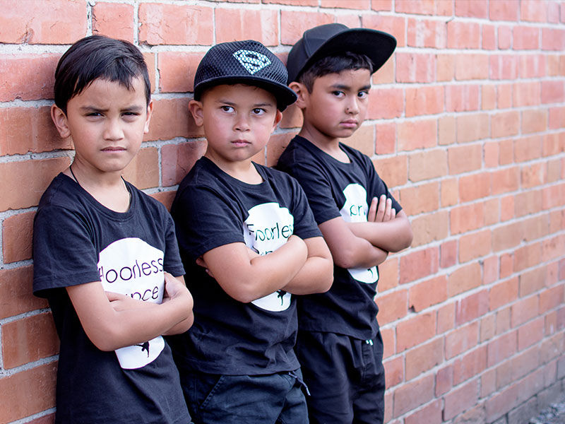 Boys leaning on brick wall